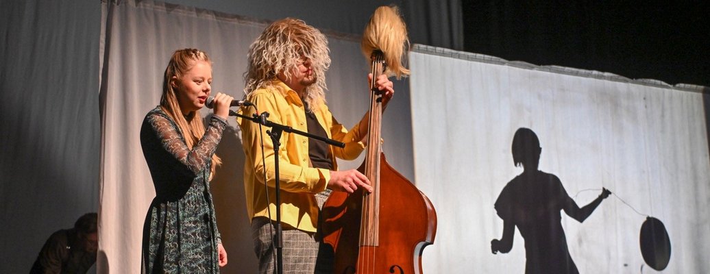 Eine junge Frau singt zusammen mit einem lustigen Mann mit Kontrabass
