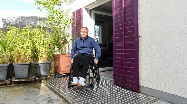 Un homme en fauteuil roulant emprunte une rampe pour se rendre dans le jardin